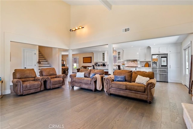 9900 Carmelita Ave, Atascadero, CA 93422 - living area with light wood finished floors, stairway, beamed ceiling, and high vaulted ceiling