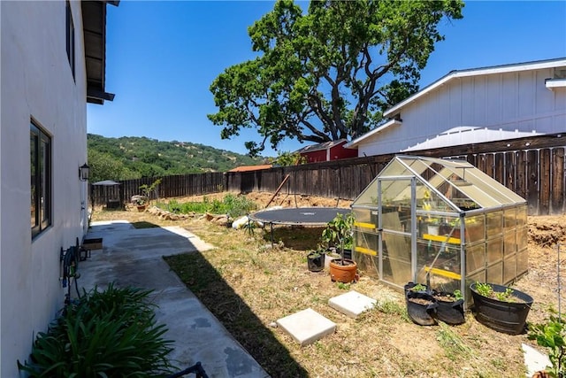 9900 Carmelita Ave, Atascadero, CA 93422 - fenced backyard featuring a greenhouse, an outdoor structure, and a patio
