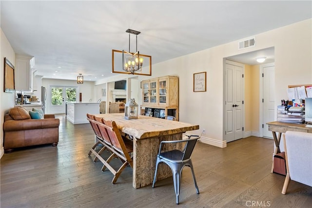 9900 Carmelita Ave, Atascadero, CA 93422 - dining room with dark wood-type flooring, baseboards, a chandelier, and a fireplace