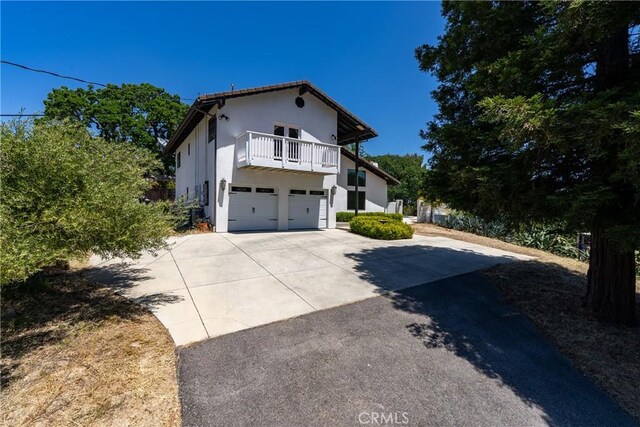 9900 Carmelita Ave, Atascadero, CA 93422 - view of front of property featuring a balcony, driveway, stucco siding, and a garage
