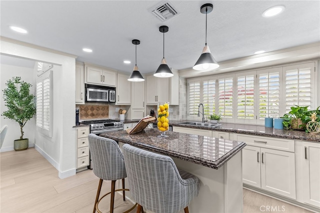 3094 Windemere Ct, Chino Hills, CA 91709 - kitchen featuring stainless steel microwave, a sink, decorative backsplash, light wood finished floors, and a kitchen island