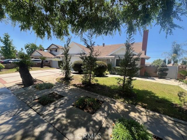 239 N Basilio Ave, San Dimas, CA 91773 - view of property hidden behind natural elements with driveway and an attached garage