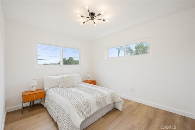 239 N Basilio Ave, San Dimas, CA 91773 - bedroom featuring a chandelier, baseboards, and light wood-style flooring