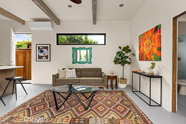 4958 Highland View Ave, Los Angeles, CA 90041 - living room with a wall mounted air conditioner, beam ceiling, ceiling fan, and finished concrete floors