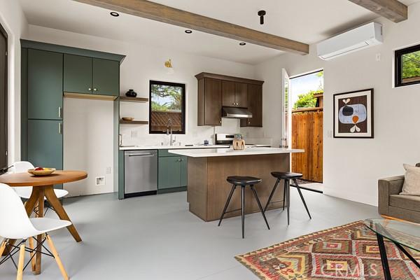 4958 Highland View Ave, Los Angeles, CA 90041 - kitchen featuring stainless steel appliances, under cabinet range hood, a wall mounted air conditioner, beamed ceiling, and green cabinetry