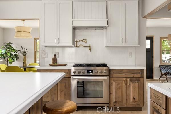 4958 Highland View Ave, Los Angeles, CA 90041 - kitchen featuring high end range, light countertops, custom range hood, and brown cabinets
