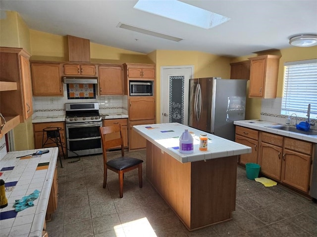 36255 Grapevine Canyon Rd, Ranchita, CA 92066 - kitchen featuring stainless steel appliances, tile counters, a skylight, a sink, and under cabinet range hood