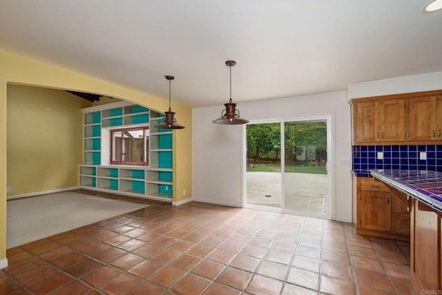 398 Aliso St, Ventura, CA 93001 - kitchen with tile counters, decorative light fixtures, tasteful backsplash, and brown cabinetry