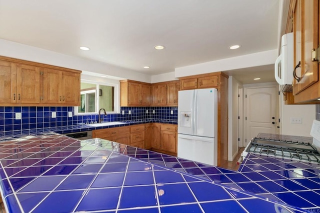 398 Aliso St, Ventura, CA 93001 - kitchen with white appliances, tile counters, a sink, decorative backsplash, and brown cabinetry