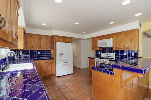398 Aliso St, Ventura, CA 93001 - kitchen with white appliances, tile countertops, a sink, a peninsula, and tasteful backsplash