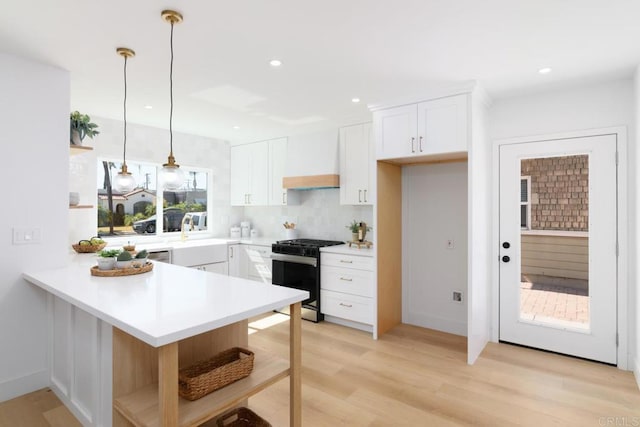 444547 N 42nd St, San Diego, CA 92116 - kitchen with stainless steel gas range, premium range hood, a peninsula, white cabinets, and recessed lighting