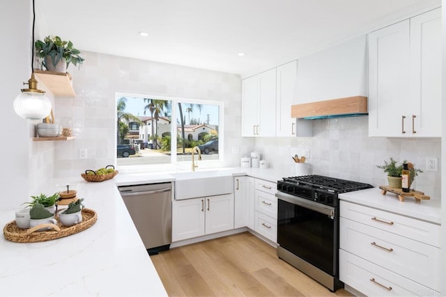 444547 N 42nd St, San Diego, CA 92116 - kitchen featuring dishwasher, range with gas cooktop, premium range hood, a sink, and white cabinetry