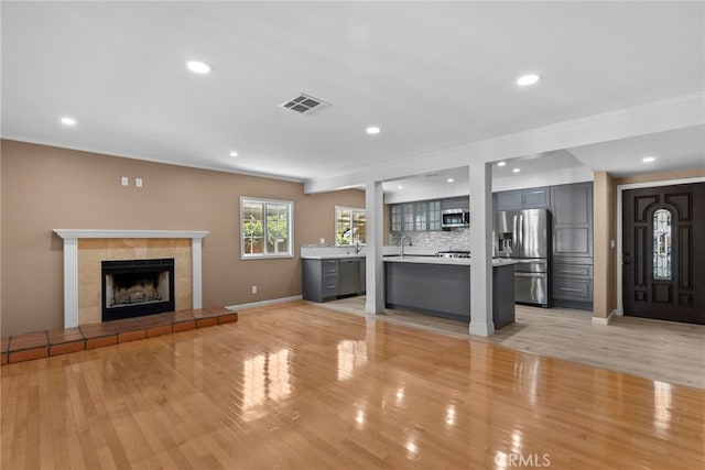 15711 Hiawatha St, Granada Hills, CA 91344 - unfurnished living room featuring a tiled fireplace, light wood-style flooring, baseboards, crown molding, and recessed lighting