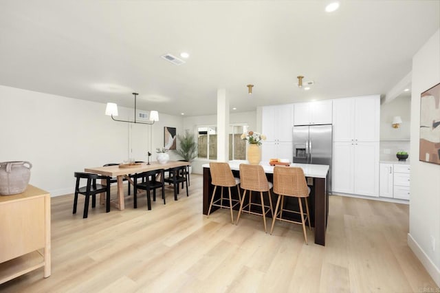 23162 La Vaca St, Lake Forest, CA 92630 - kitchen with light wood-style flooring, a kitchen breakfast bar, white cabinetry, light countertops, and built in fridge