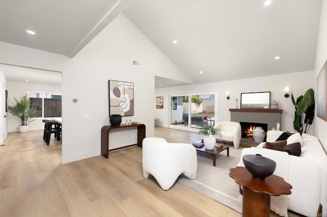 23162 La Vaca St, Lake Forest, CA 92630 - living room featuring light wood-type flooring, plenty of natural light, recessed lighting, a warm lit fireplace, and high vaulted ceiling