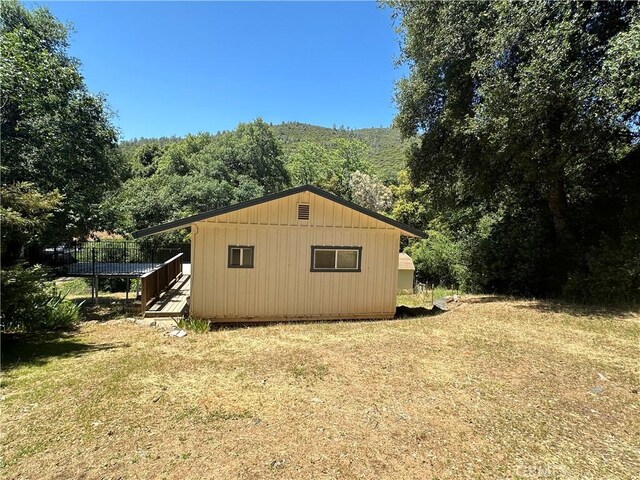 20853 Lyons Bald Mountain Rd, Sonora, CA 95370 - view of side of home featuring a forest view, a wooden deck, and a lawn