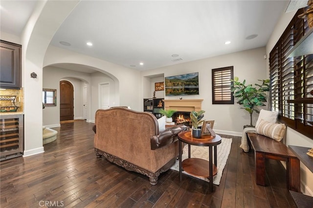 24 Tree Clover, Irvine, CA 92618 - living room with beverage cooler, wood-type flooring, baseboards, arched walkways, and a warm lit fireplace