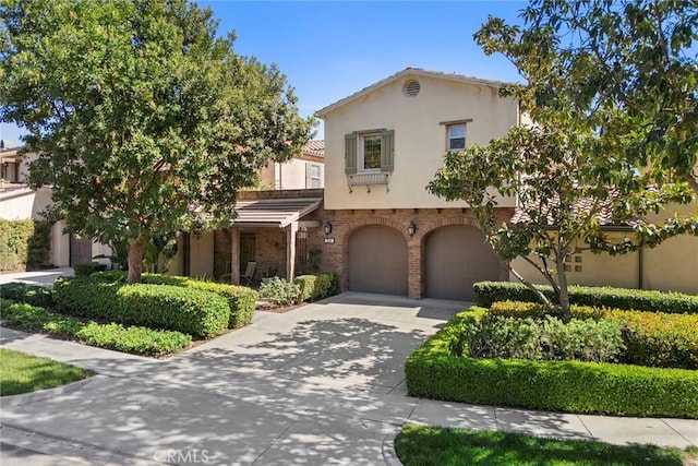 24 Tree Clover, Irvine, CA 92618 - view of front of property with concrete driveway, an attached garage, stucco siding, and brick siding