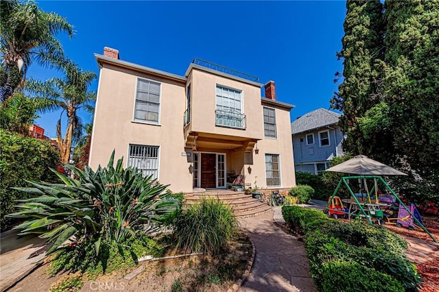 1151 Arapahoe St, Los Angeles, CA 90006 - view of front of house with a chimney, stucco siding, and a playground