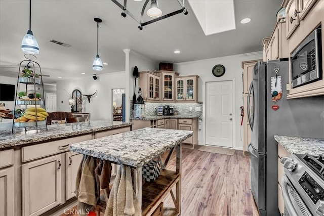 17276 Iona Ave, Lemoore, CA 93245 - kitchen featuring stainless steel appliances, crown molding, light wood-type flooring, glass insert cabinets, and pendant lighting