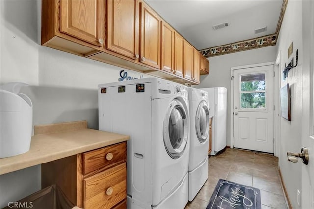 17276 Iona Ave, Lemoore, CA 93245 - laundry area featuring cabinet space, washing machine and clothes dryer, and light tile patterned flooring
