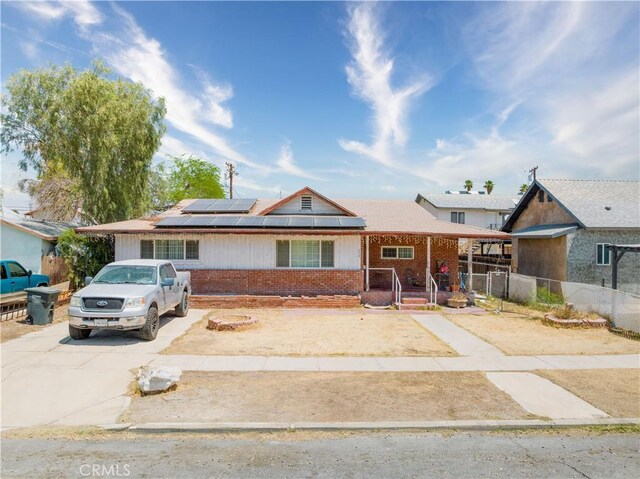 634 W Holt Ave, El Centro, CA 92243 - single story home featuring brick siding, solar panels, covered porch, and driveway