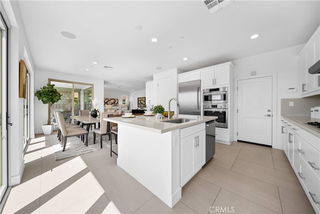 1844 Aliso Canyon Dr, Lake Forest, CA 92610 - kitchen with a sink, recessed lighting, appliances with stainless steel finishes, a kitchen island with sink, and white cabinetry