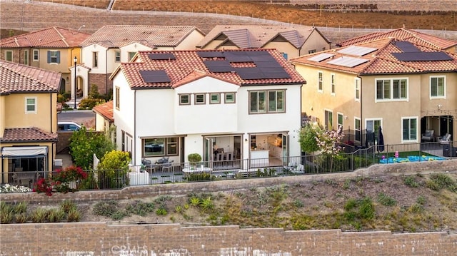1844 Aliso Canyon Dr, Lake Forest, CA 92610 - back of house featuring stucco siding, a fenced backyard, solar panels, and a tile roof