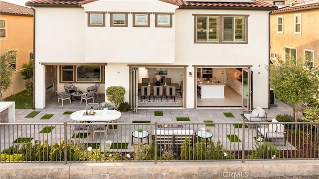1844 Aliso Canyon Dr, Lake Forest, CA 92610 - back of property featuring stucco siding, a tiled roof, a patio, and roof mounted solar panels