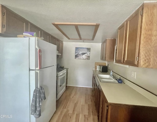 2711 S El Camino Real Unit 7, San Clemente, CA 92672 - kitchen with freestanding refrigerator, range with gas cooktop, light wood-style floors, a sink, and light countertops