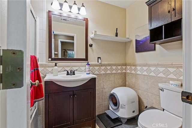 1457 Quiet Ct, Merced, CA 95340 - full bathroom with tile walls, toilet, a wainscoted wall, and vanity