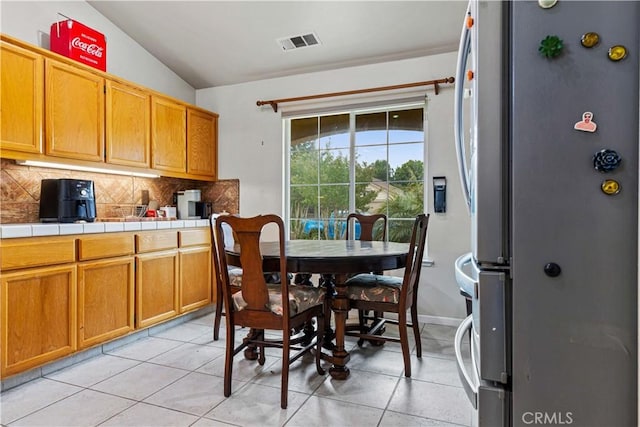 1457 Quiet Ct, Merced, CA 95340 - dining room with lofted ceiling, light tile patterned floors, and baseboards