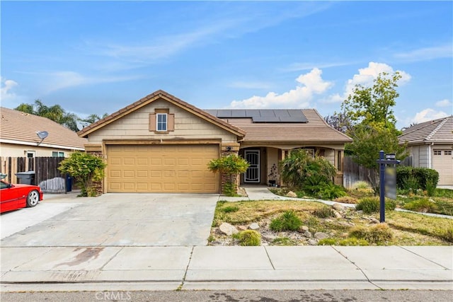 1457 Quiet Ct, Merced, CA 95340 - view of front of house with roof mounted solar panels, a garage, and driveway
