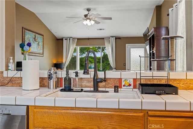 1457 Quiet Ct, Merced, CA 95340 - kitchen featuring tile countertops, a sink, ceiling fan, dishwasher, and lofted ceiling
