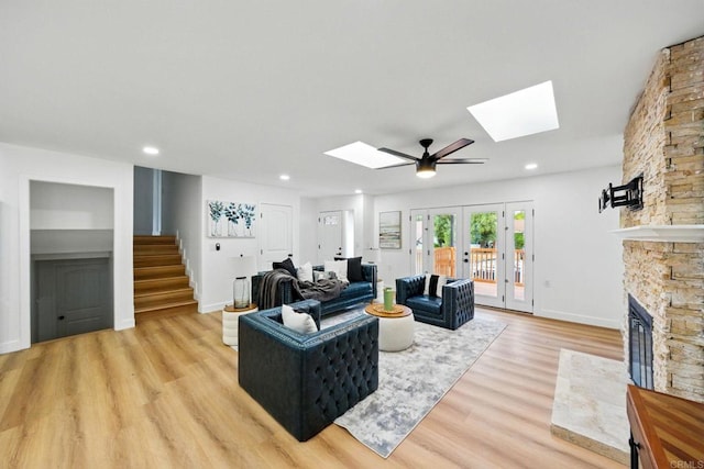 4848 54th St, San Diego, CA 92115 - living area with a skylight, stairs, light wood-style flooring, a stone fireplace, and recessed lighting