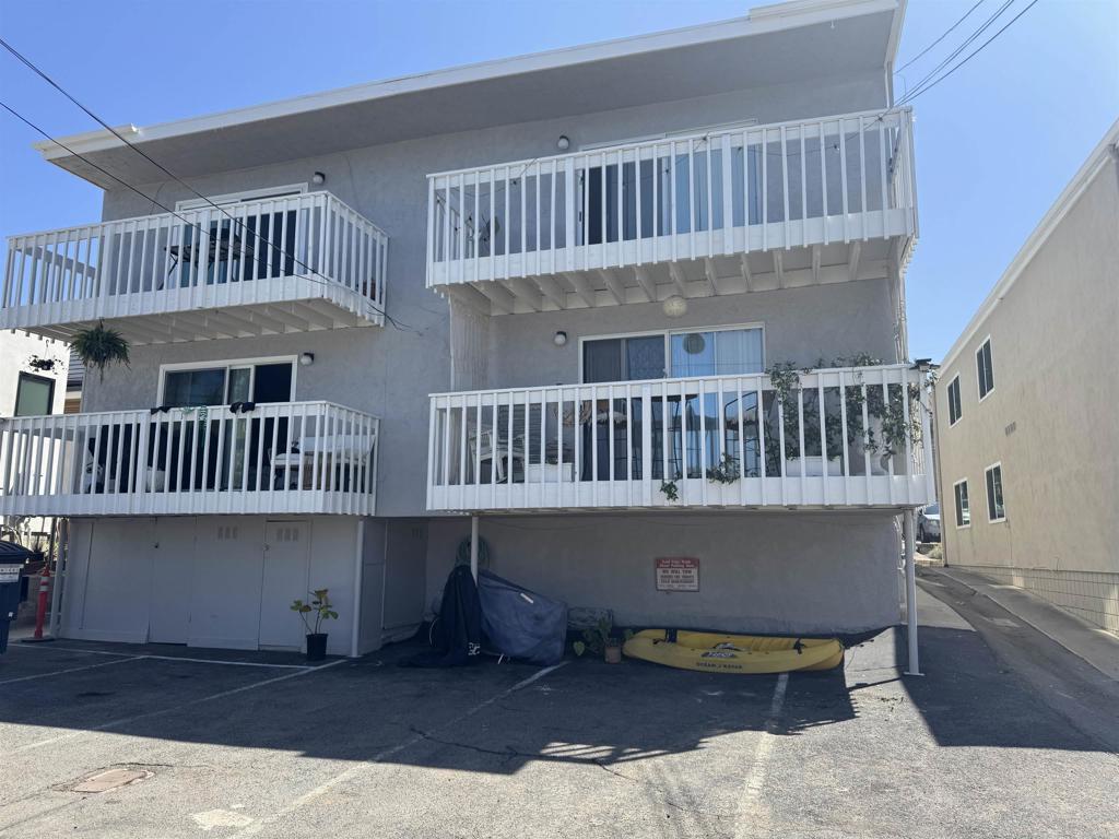 2068 Montgomery Ave, Cardiff By The Sea, CA 92007 - back of house with stucco siding, a balcony, and uncovered parking