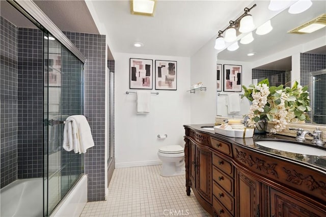 2383 Via Mariposa W Unit C, Laguna Woods, CA 92637 - bathroom featuring toilet, double vanity, tile patterned flooring, baseboards, and enclosed tub / shower combo