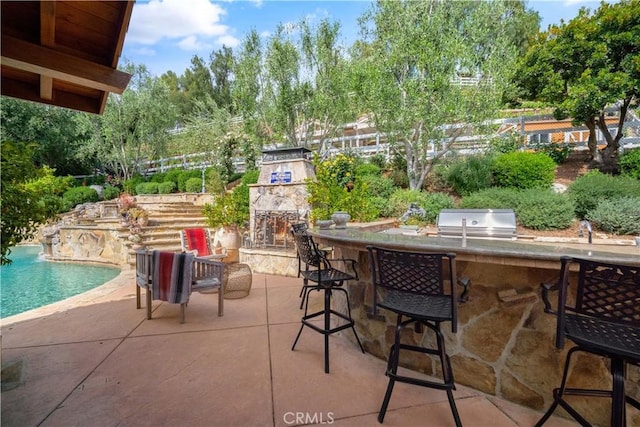 5558 Hoback Glen Rd, Hidden Hills, CA 91302 - view of patio / terrace with an outdoor stone fireplace, a bar, an outdoor pool, and view of wooded area