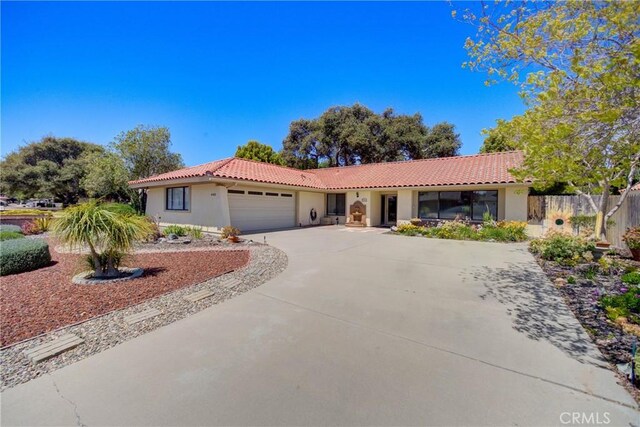 4185 Vanguard Dr, Lompoc, CA 93436 - mediterranean / spanish-style house with stucco siding, a tile roof, an attached garage, and concrete driveway