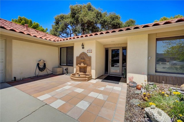 4185 Vanguard Dr, Lompoc, CA 93436 - view of exterior entry with a patio area, stucco siding, and a tiled roof