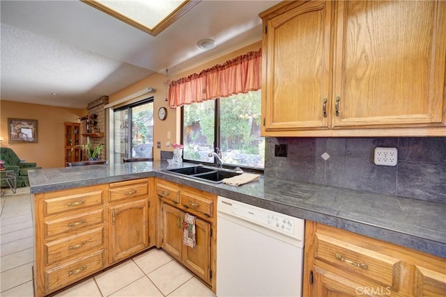 4185 Vanguard Dr, Lompoc, CA 93436 - kitchen featuring white dishwasher, a peninsula, light tile patterned floors, decorative backsplash, and a textured ceiling