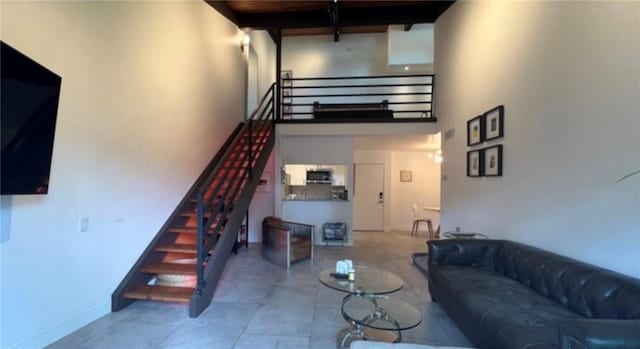 5460 White Oak Ave Unit A305, Encino, CA 91316 - living room with a towering ceiling, stairway, baseboards, and tile patterned floors