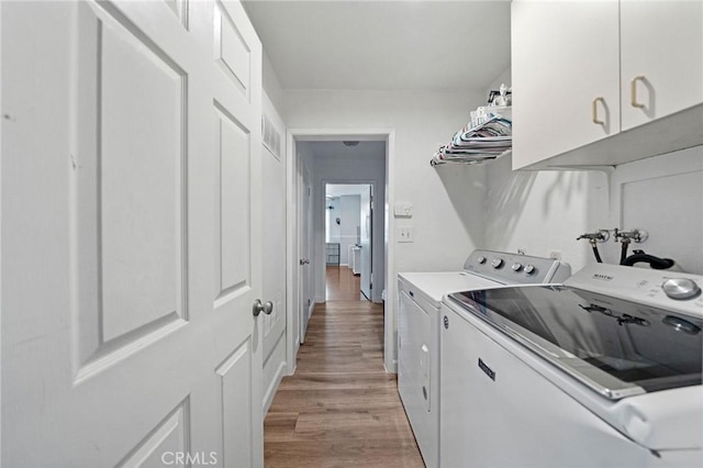 27175 Via Debra, Menifee, CA 92586 - laundry area with cabinet space, washing machine and clothes dryer, and light wood-style flooring