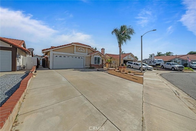 27175 Via Debra, Menifee, CA 92586 - view of front of home featuring driveway, an attached garage, a tiled roof, and a residential view