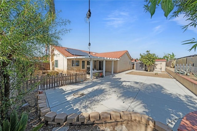 27175 Via Debra, Menifee, CA 92586 - back of house featuring solar panels, stucco siding, a patio, and a fenced backyard