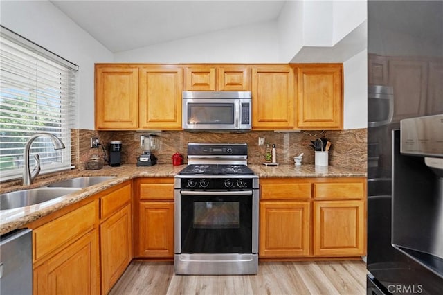 27175 Via Debra, Menifee, CA 92586 - kitchen featuring stainless steel appliances, a sink, lofted ceiling, light wood-type flooring, and light stone countertops