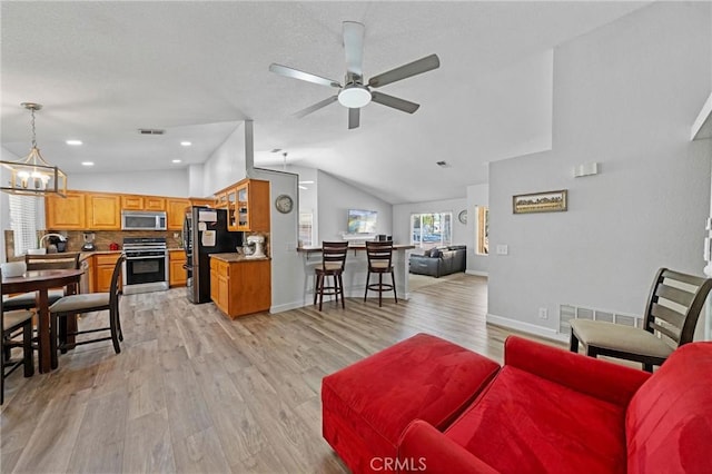 27175 Via Debra, Menifee, CA 92586 - living room featuring a ceiling fan, vaulted ceiling, light wood finished floors, a chandelier, and baseboards
