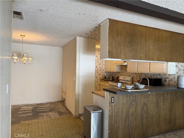 9025 Willis Ave Unit 141, Panorama City, CA 91402 - kitchen with white gas range oven, a chandelier, a peninsula, a textured ceiling, and black microwave