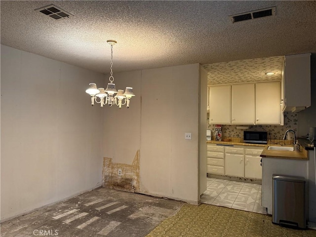 9025 Willis Ave Unit 141, Panorama City, CA 91402 - unfurnished dining area featuring a sink, a chandelier, and a textured ceiling