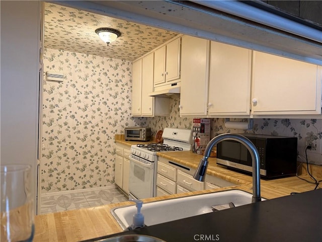 9025 Willis Ave Unit 141, Panorama City, CA 91402 - kitchen with gas range gas stove, under cabinet range hood, light tile patterned flooring, light countertops, and wallpapered walls